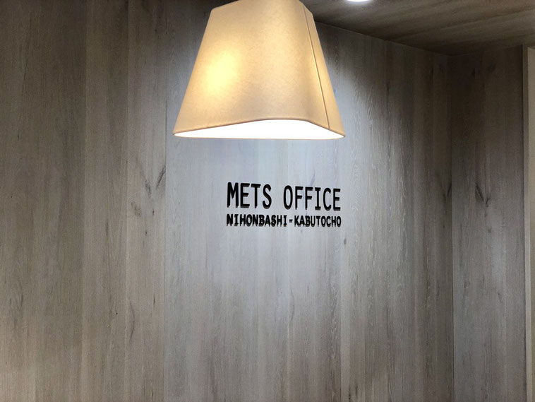 株式会社ロジックアンドデザインのオフィスが入っているMETS OFFICEのロビーには、木目調の壁に温かみのあるペンダントライトがあります